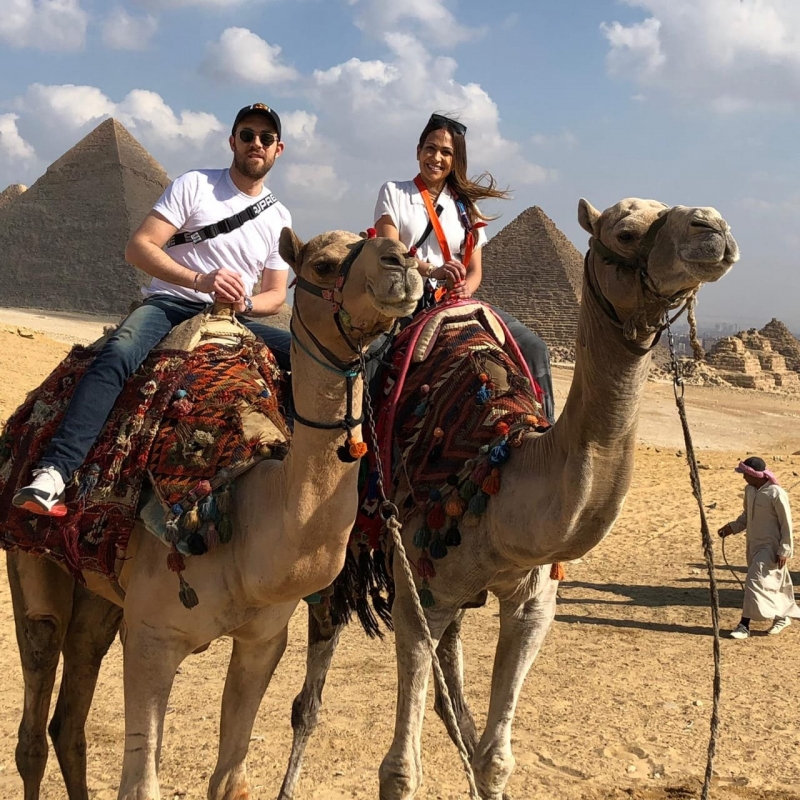 Two travellers on camels near the Giza pyramids