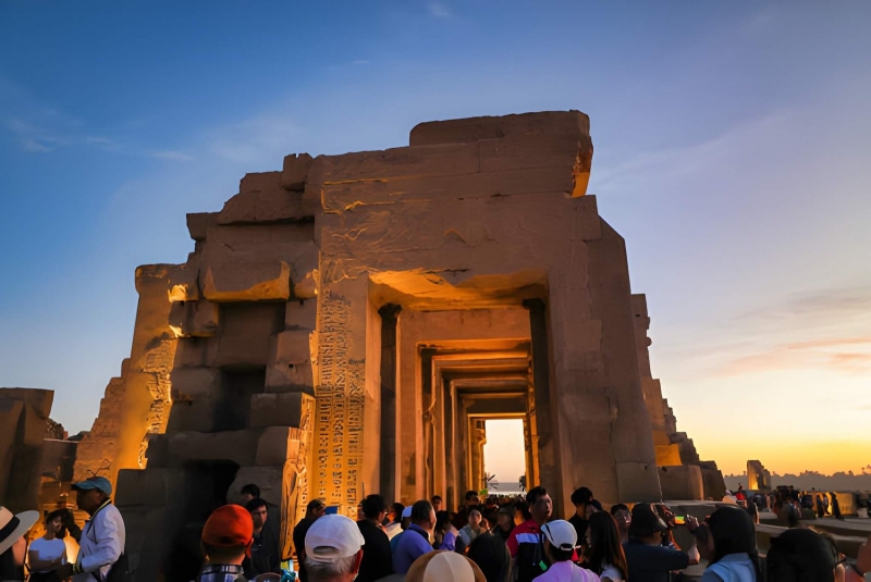 Karnak Temple gateway at sunset with visitors