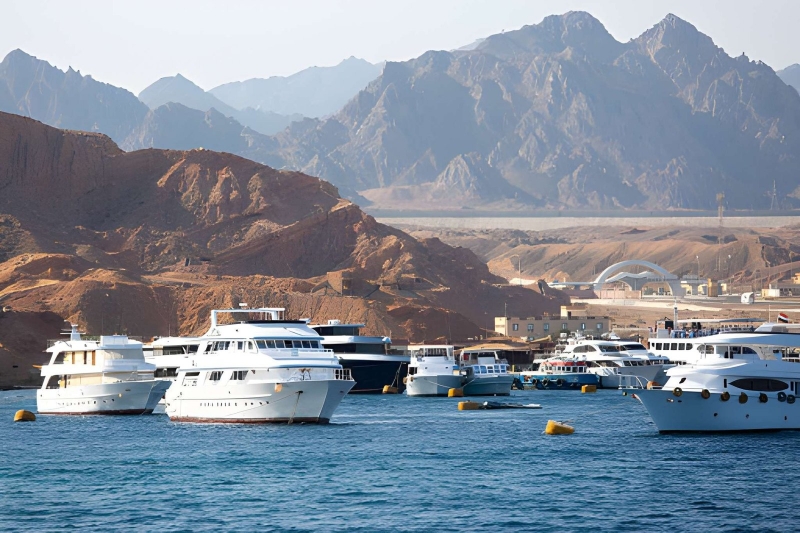 White boats moored on the Red Sea below desert mountains